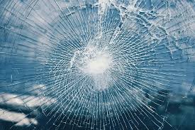 Security window film holding shattered glass together after impact